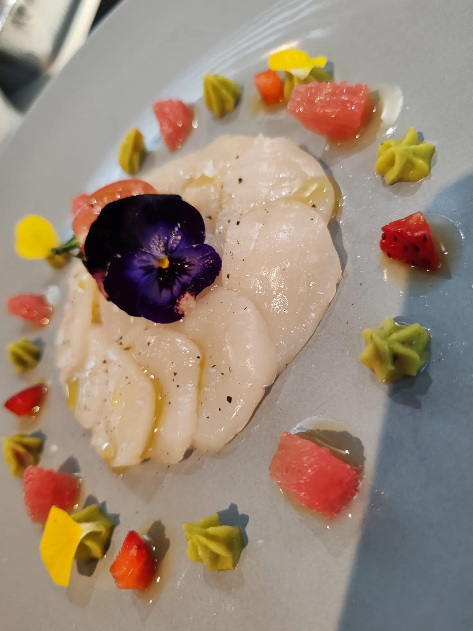 Carpaccio de Saint-Jacques, agrumes, crémeux d’avocat et fleur comestible