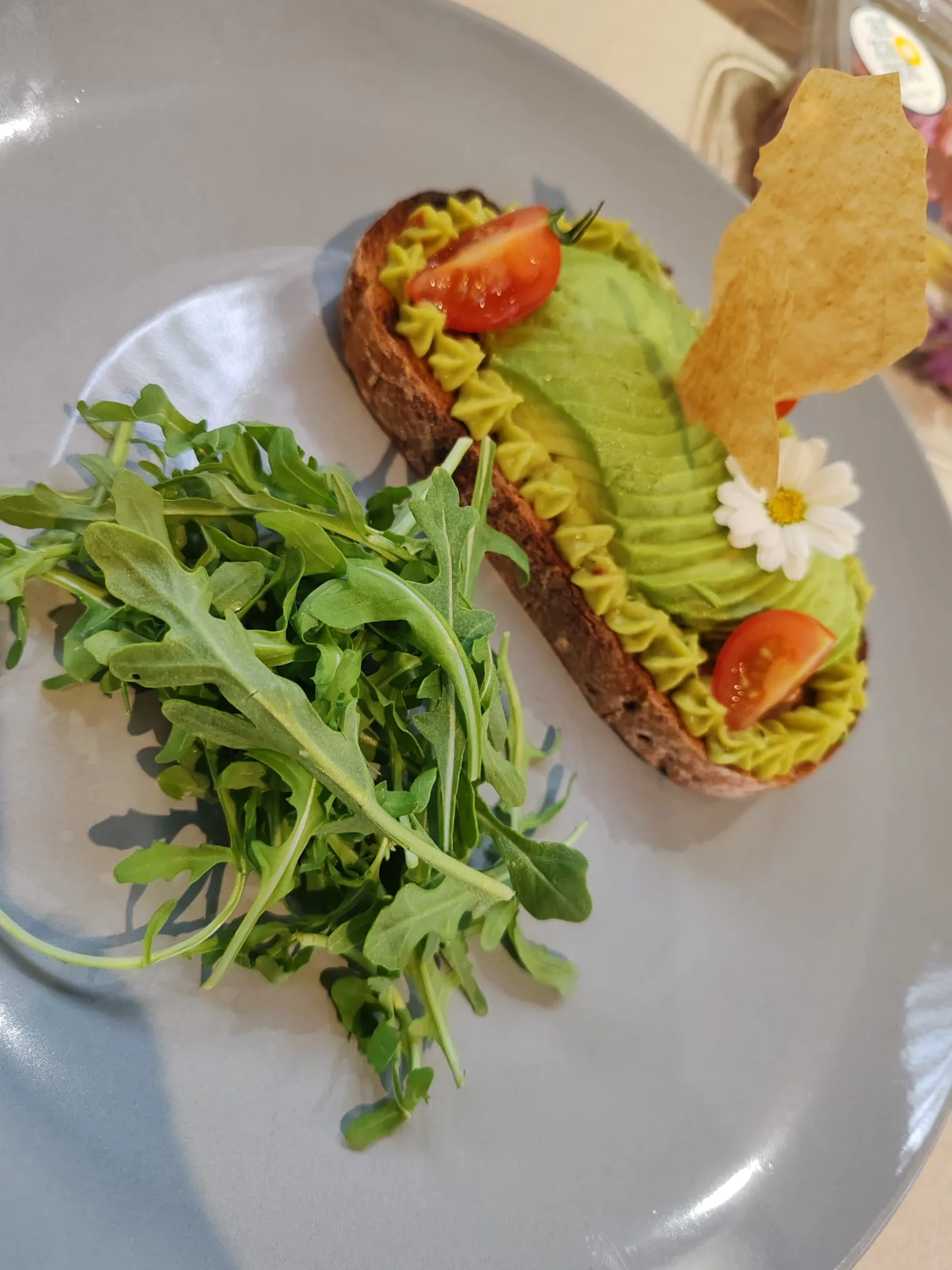 Tartine d’avocat, tomates cerises, tuile croustillante et roquette
